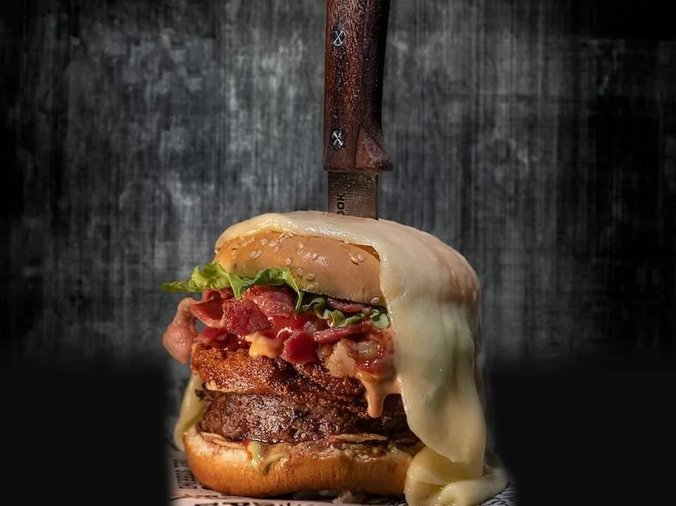 Hamburguesa De la Abuela con queso frito, maduritos, tocineta y velo de queso derretido